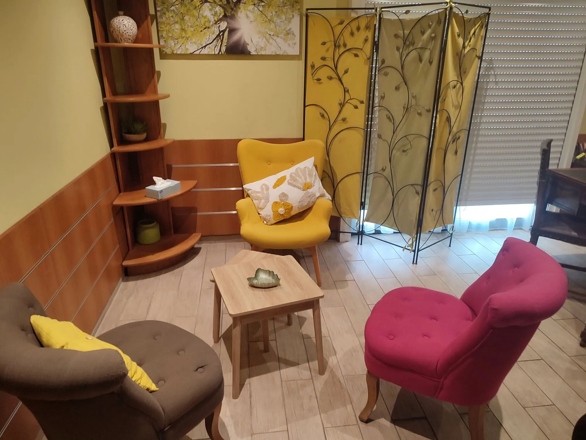 Le salon de consultation : trois fauteuils autour d'une table basse, devant un paravent